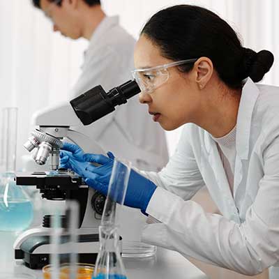 Lab team member with microscope